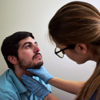 Logopeda actuando sobre la garganta de un paciente